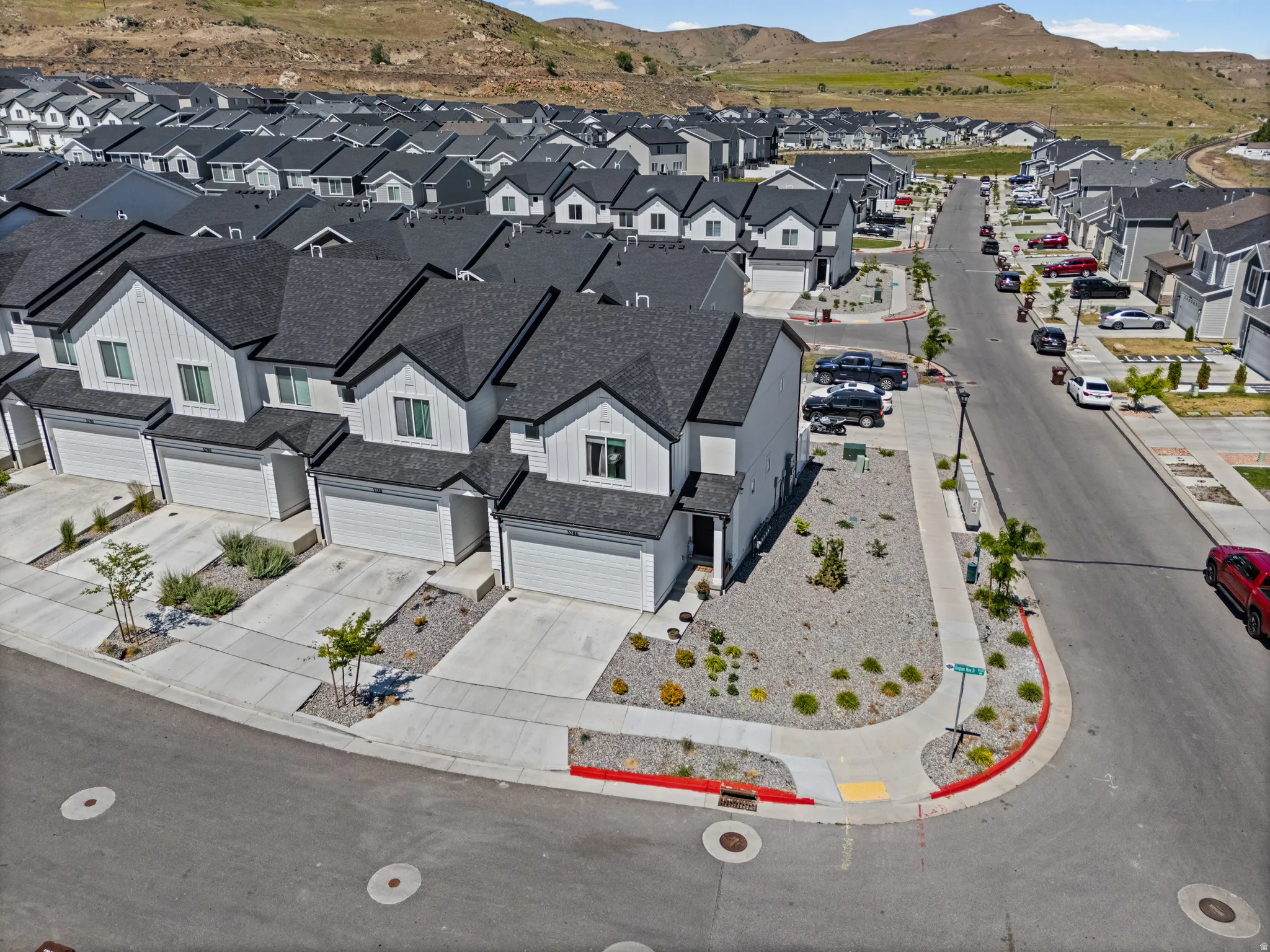 Contemporary residential development featuring multiple units with white vertical siding and dark shingle roofs