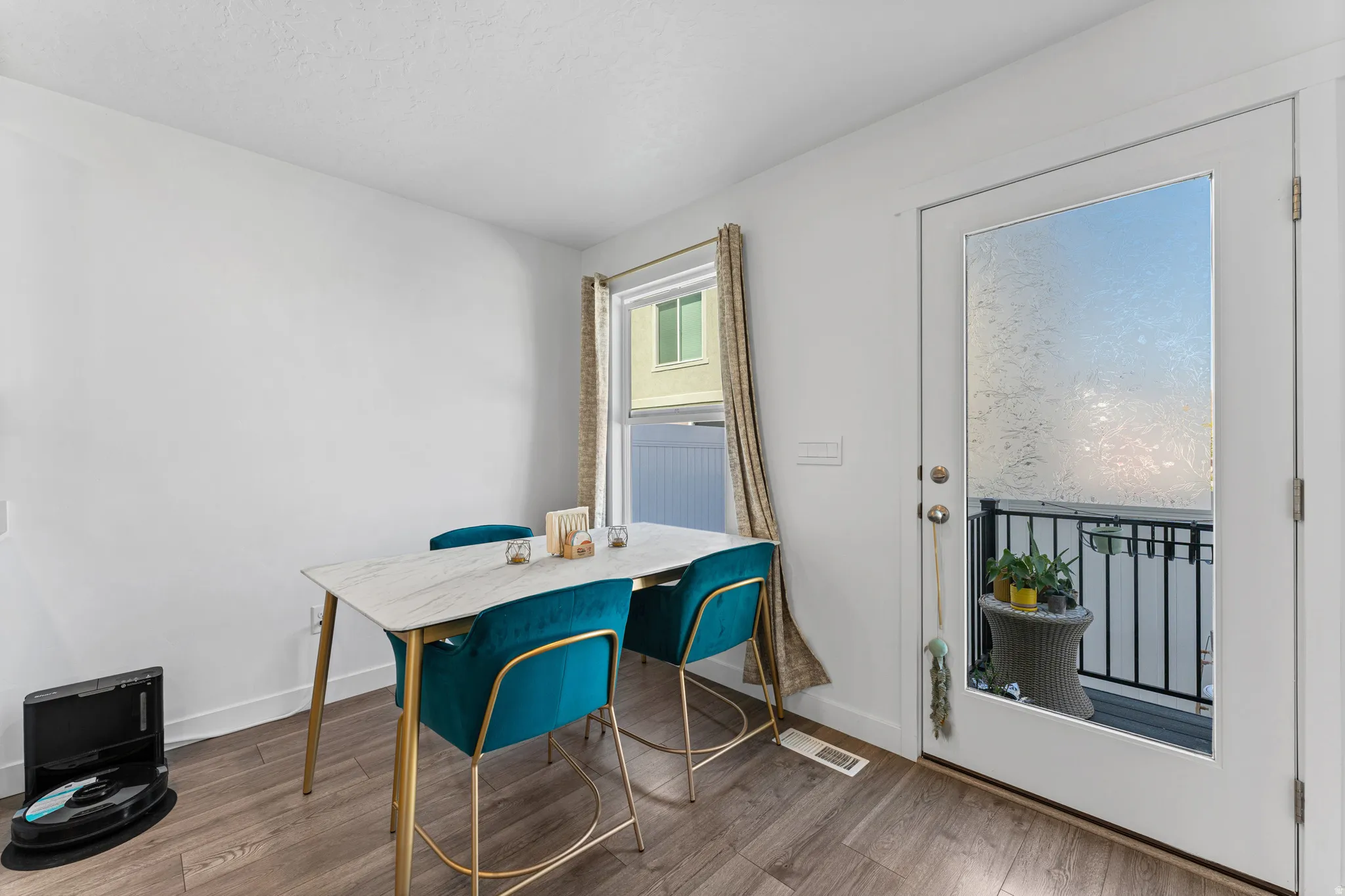 Dining area featuring wood-finish flooring, a white wall finish, and a window with natural light