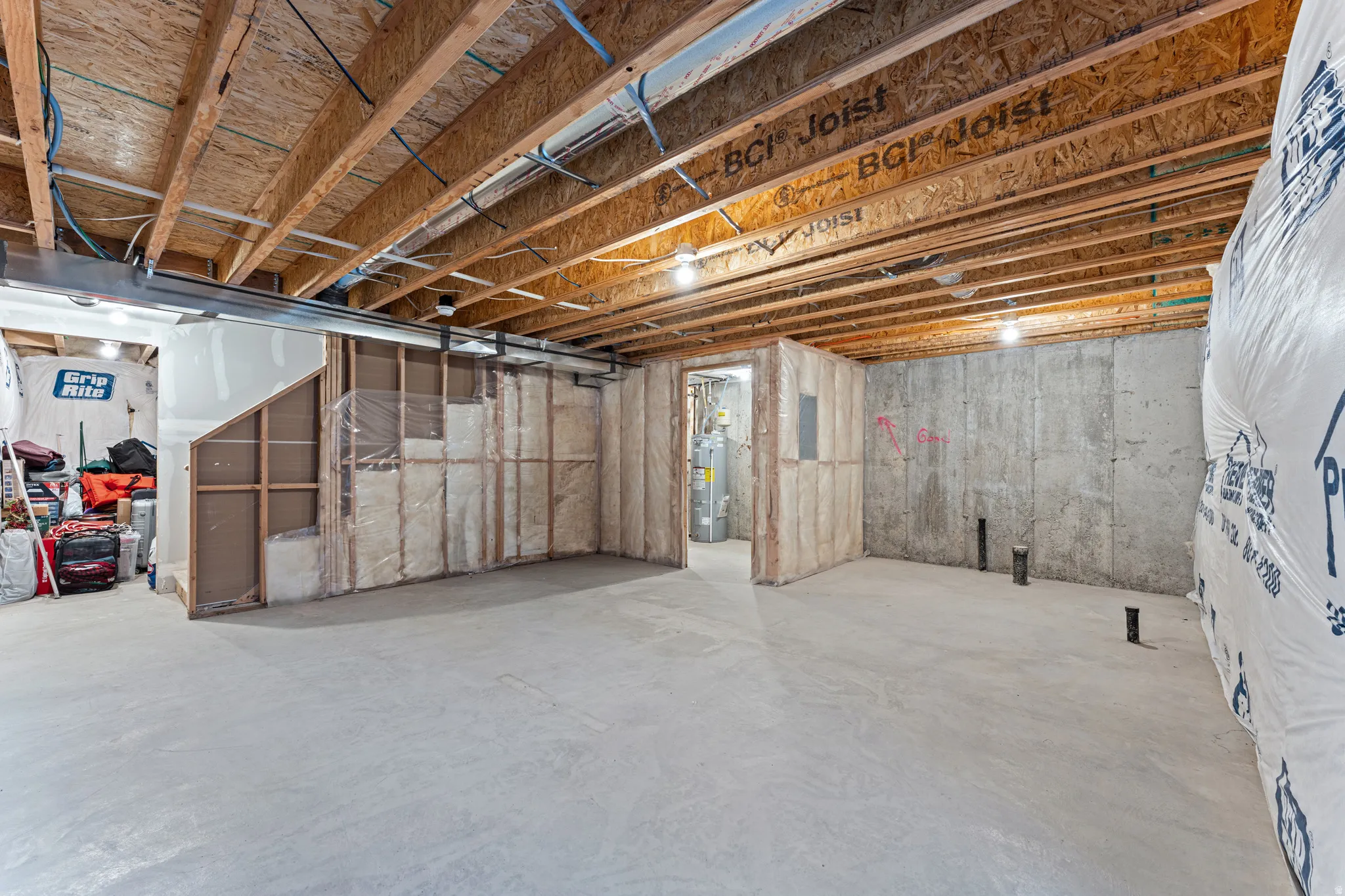 Unfinished basement with concrete flooring and exposed ceiling joists