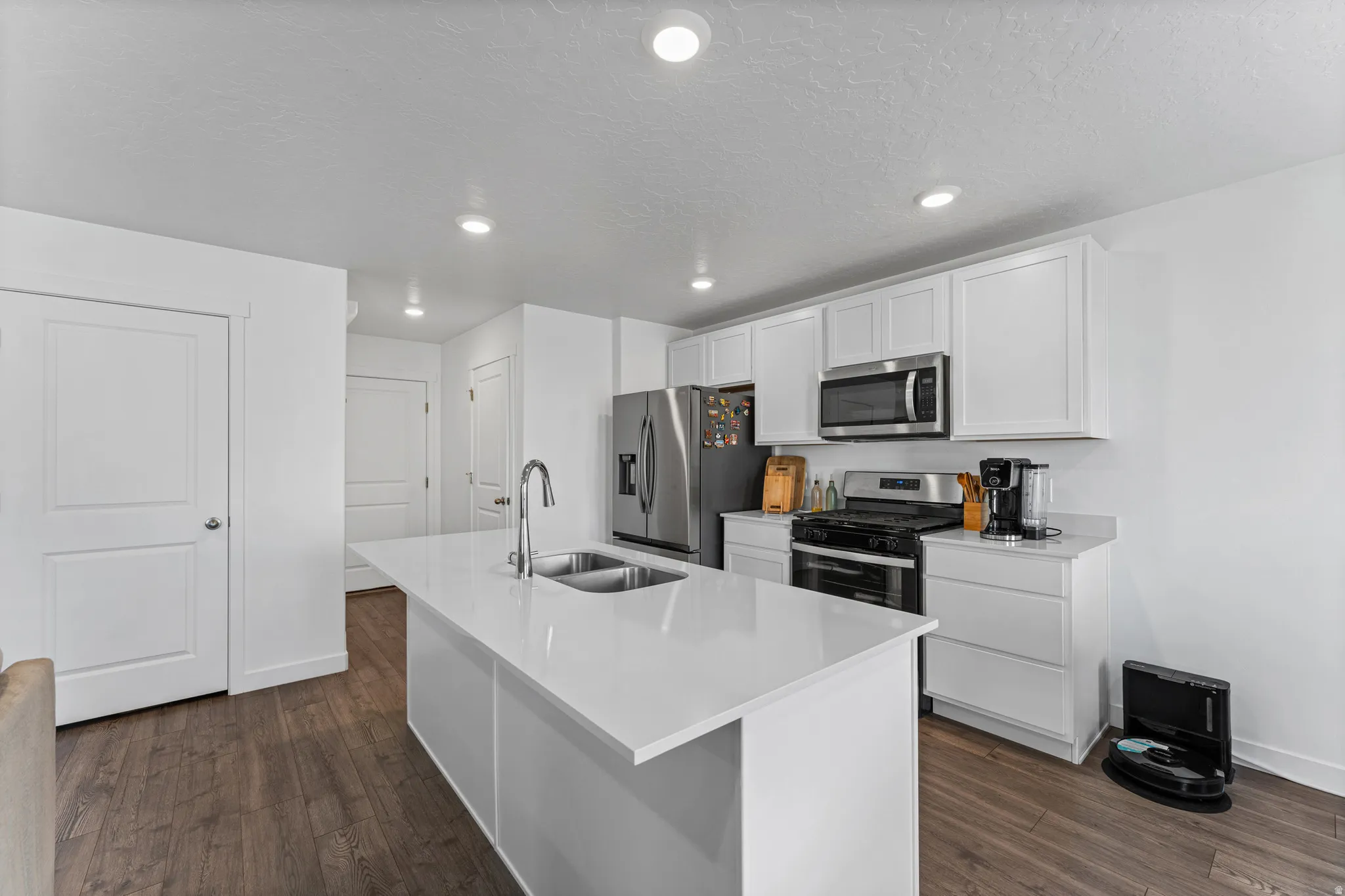 Modern kitchen featuring an expansive center island with an undermount double sink and gooseneck faucet