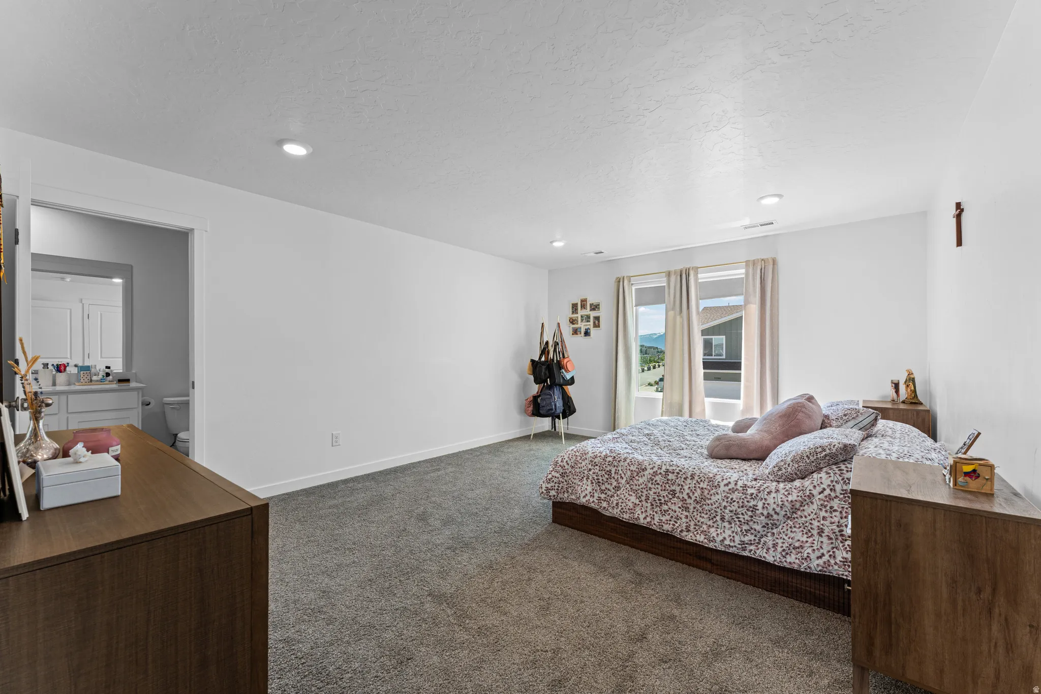 Carpeted room with recessed lighting and a window offering a distant mountain backdrop