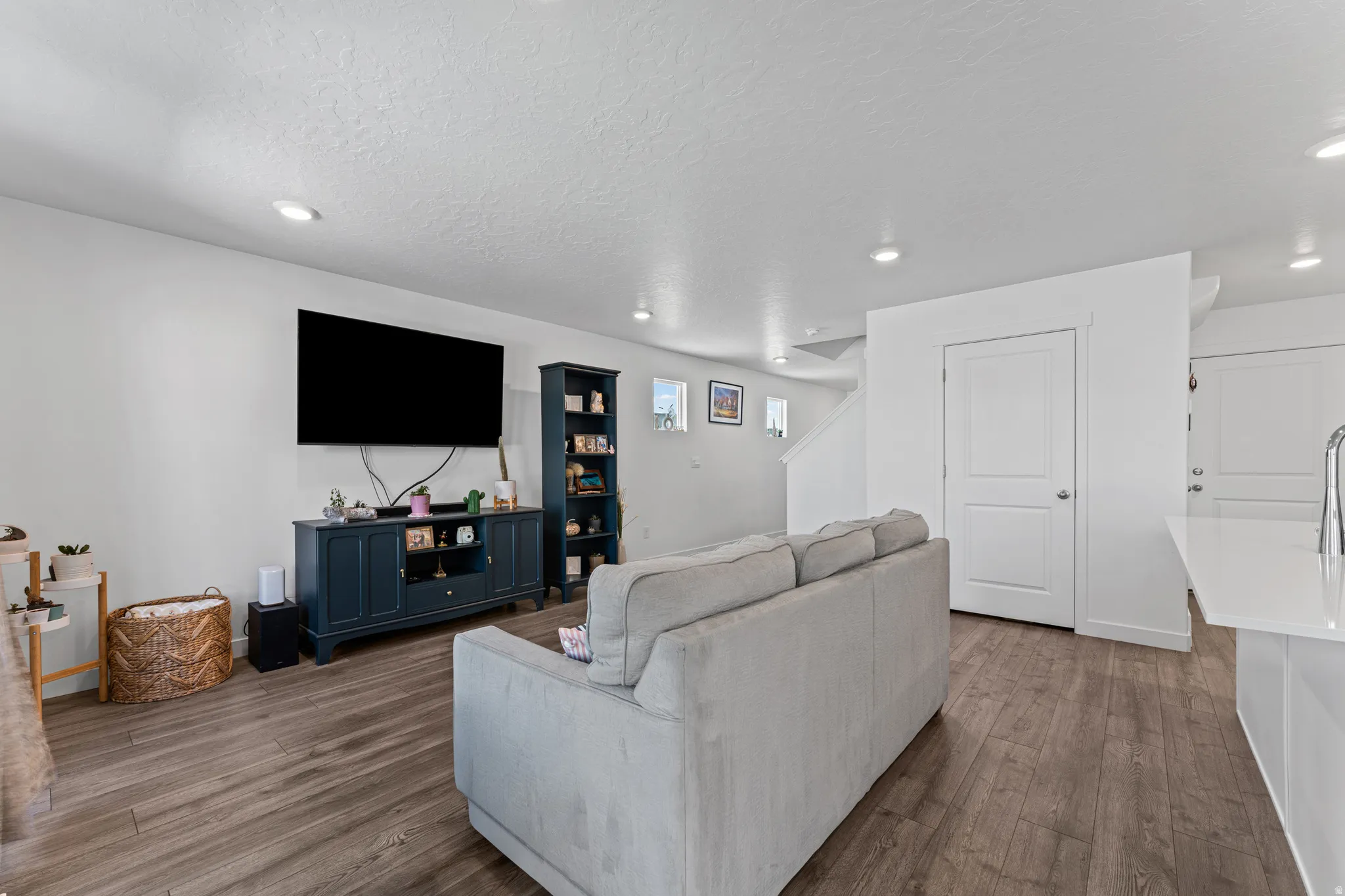 Open-concept living area featuring wood-finish flooring, recessed lighting, and white walls