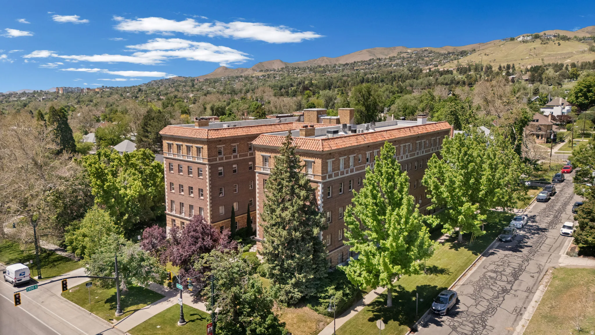 Multi-story brick building featuring a terracotta tile roof and architectural detailing