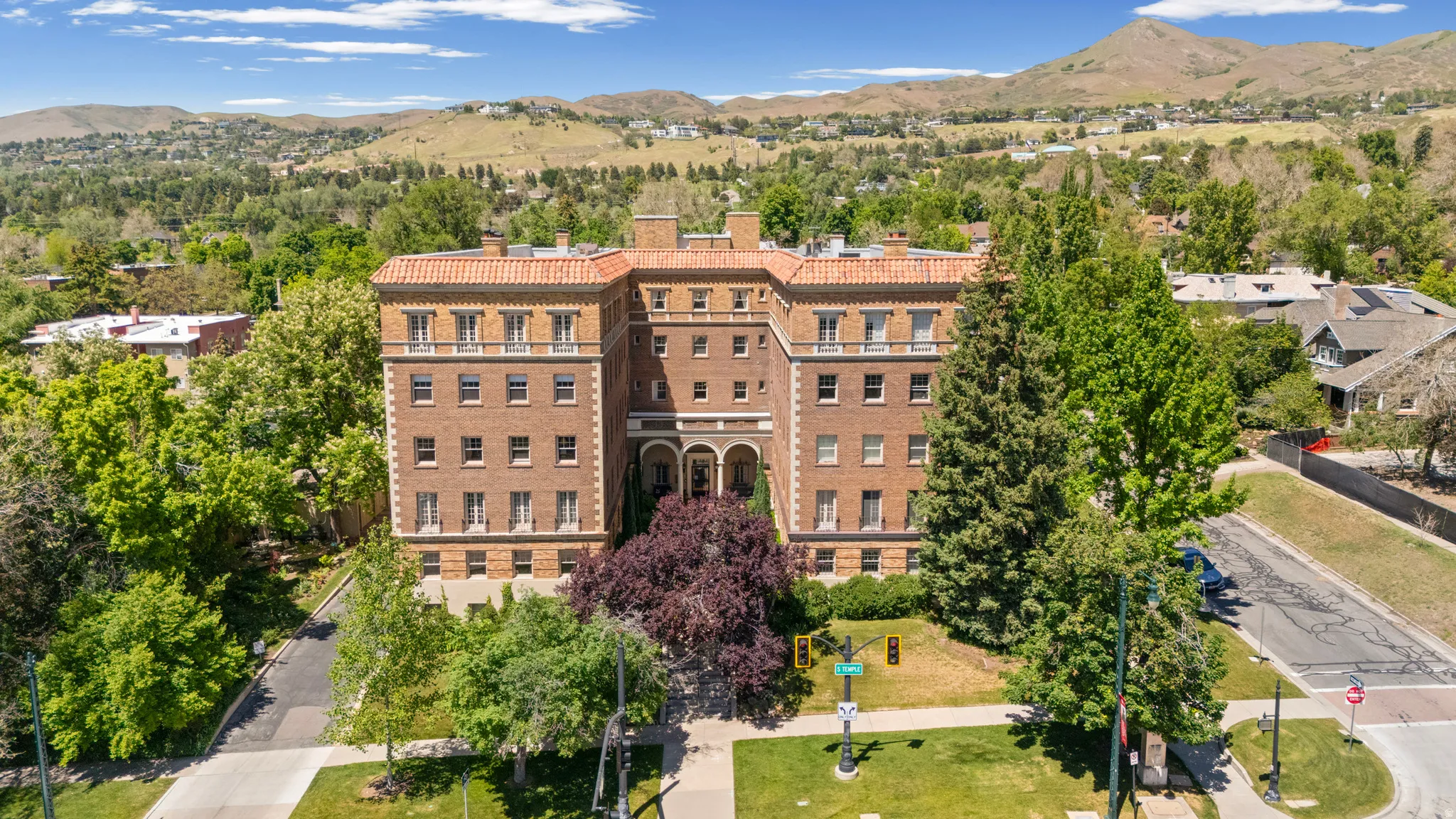 Five-story masonry building with a Mediterranean-inspired tile roof and multiple balconies