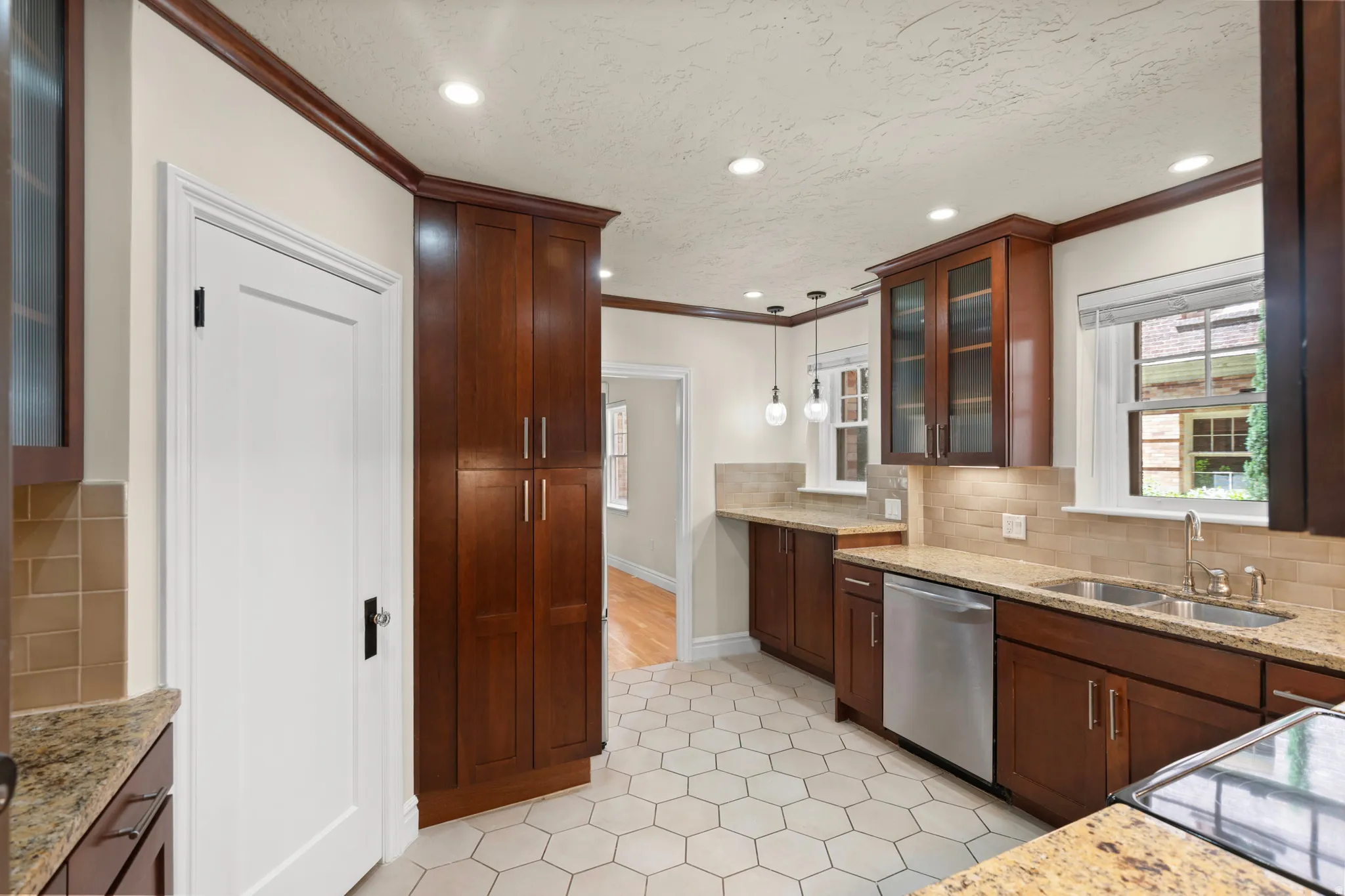 Kitchen featuring wood cabinetry, granite countertops, tile backsplash, and stainless steel appliances