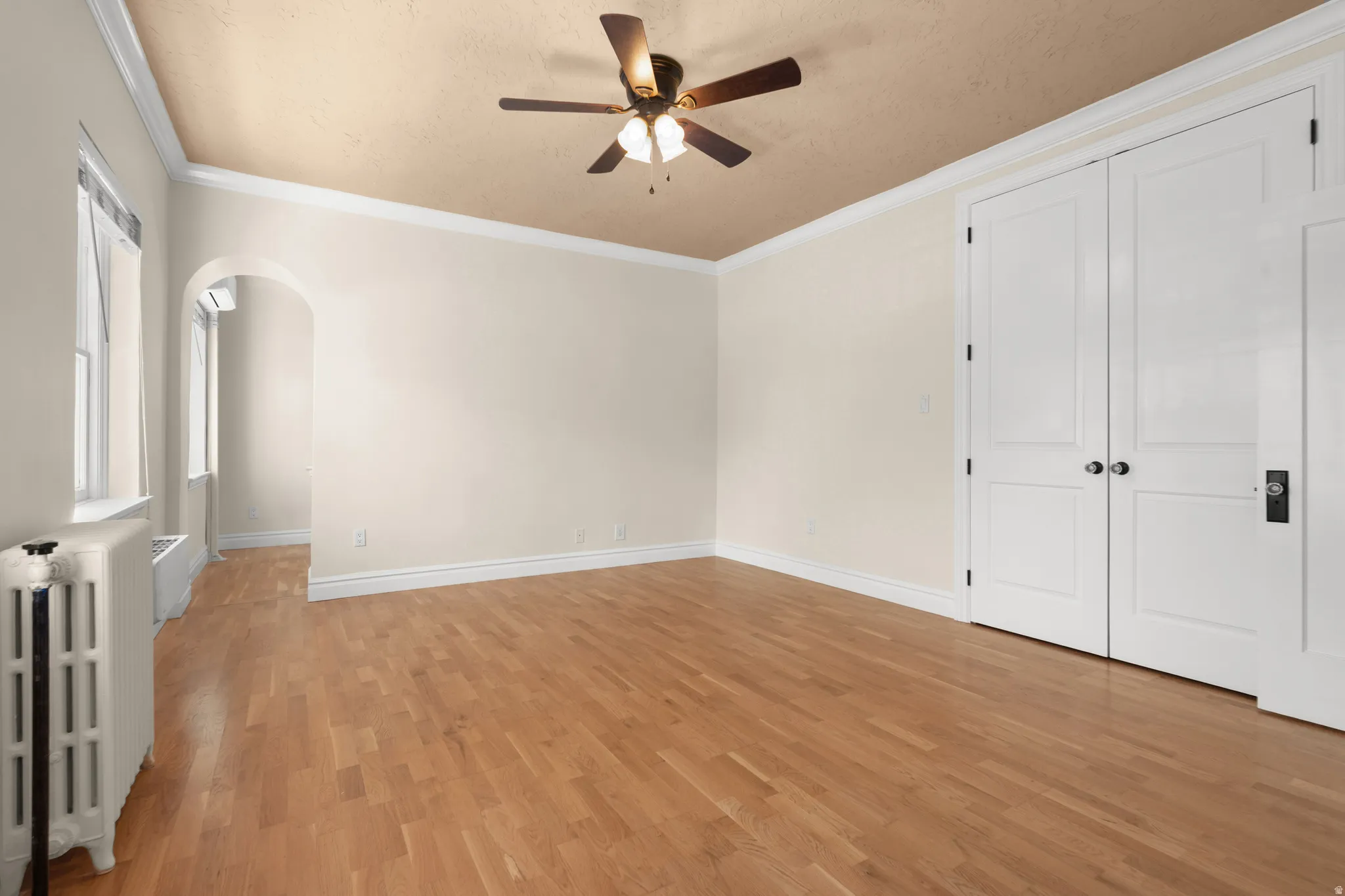Open Master bedroom space featuring wood-finish flooring, light-toned walls, and white baseboards