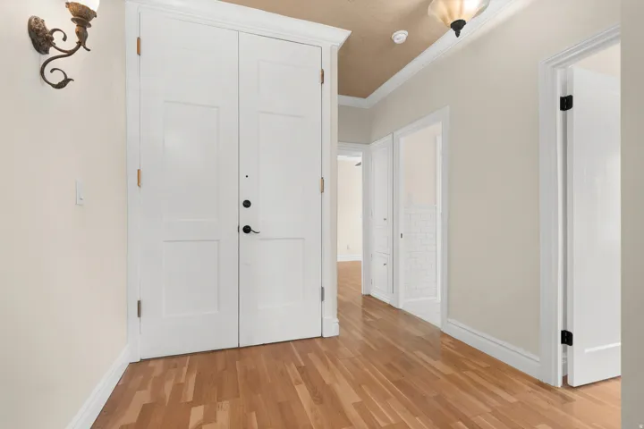 Entryway featuring wood-finish flooring, a double-panel door, and a decorative wall sconce