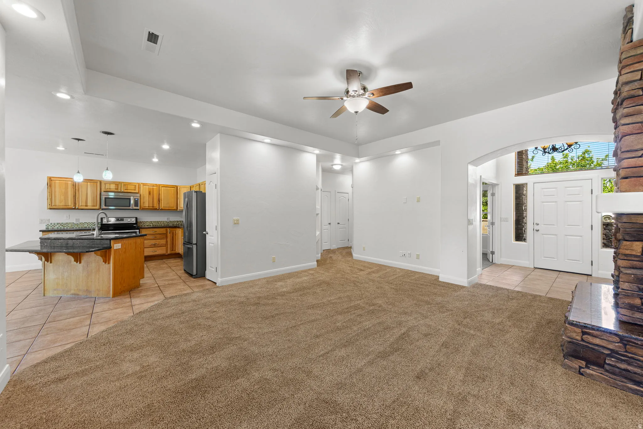 Open concept living area with carpeting, a ceiling fan, and recessed lighting