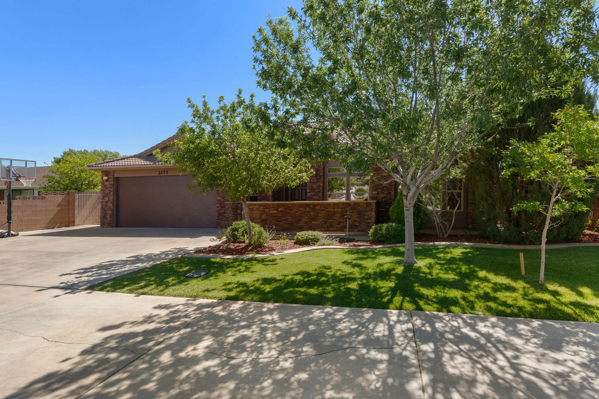 Single-story exterior with a tile roof, a two-car garage, and a concrete driveway