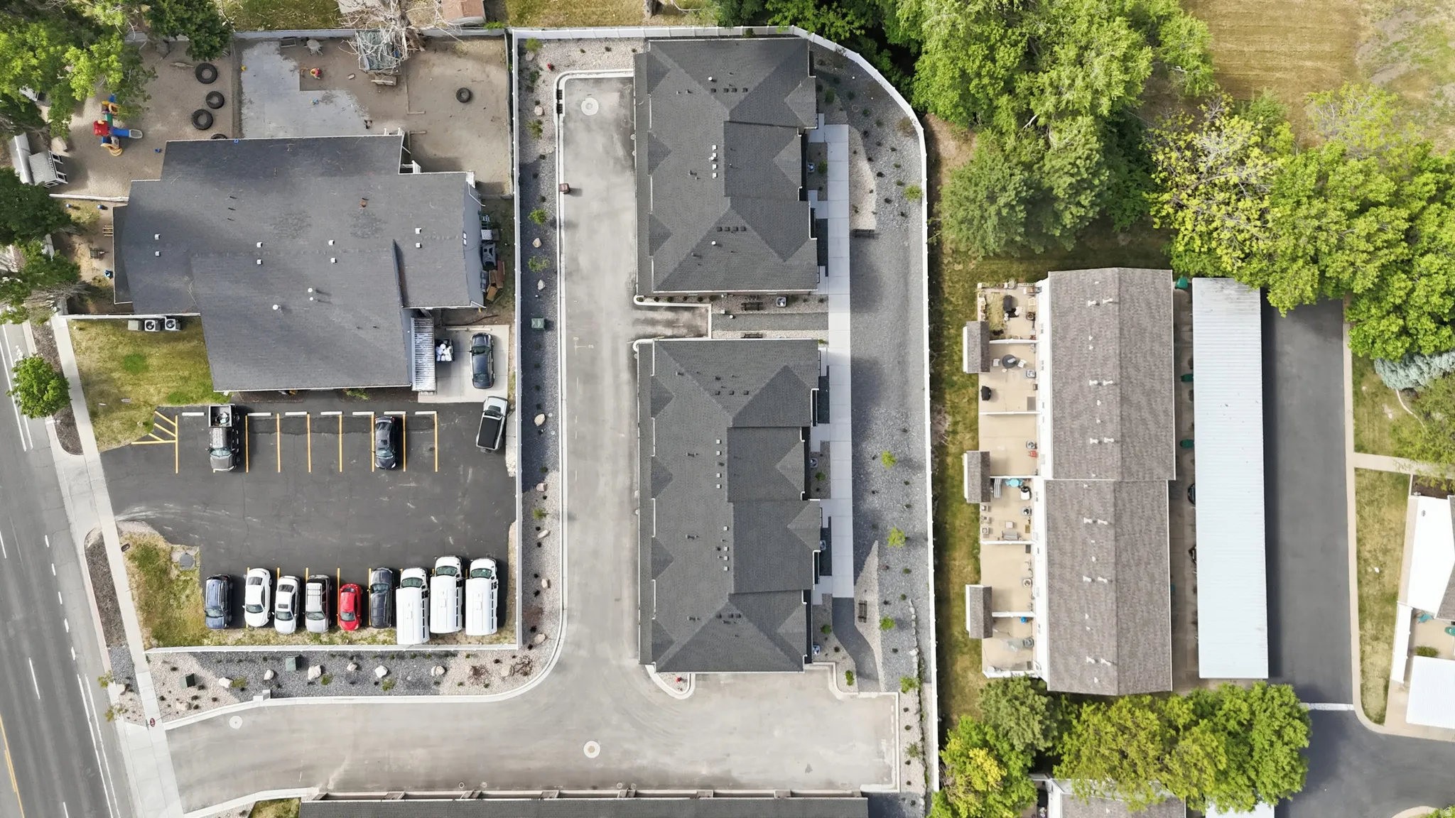 Aerial perspective showcasing a multi-building property with multiple parking areas