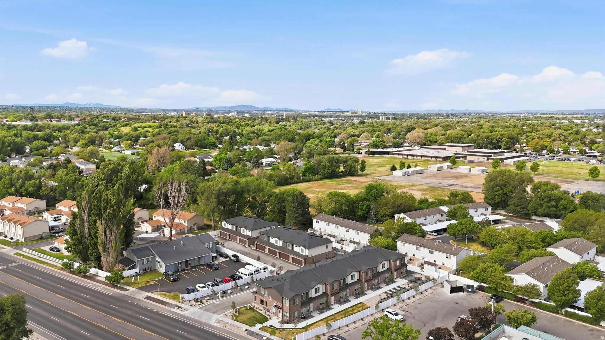 Aerial perspective showcasing multiple residential structures, including townhomes with brick and siding exteriors and individual dwellings