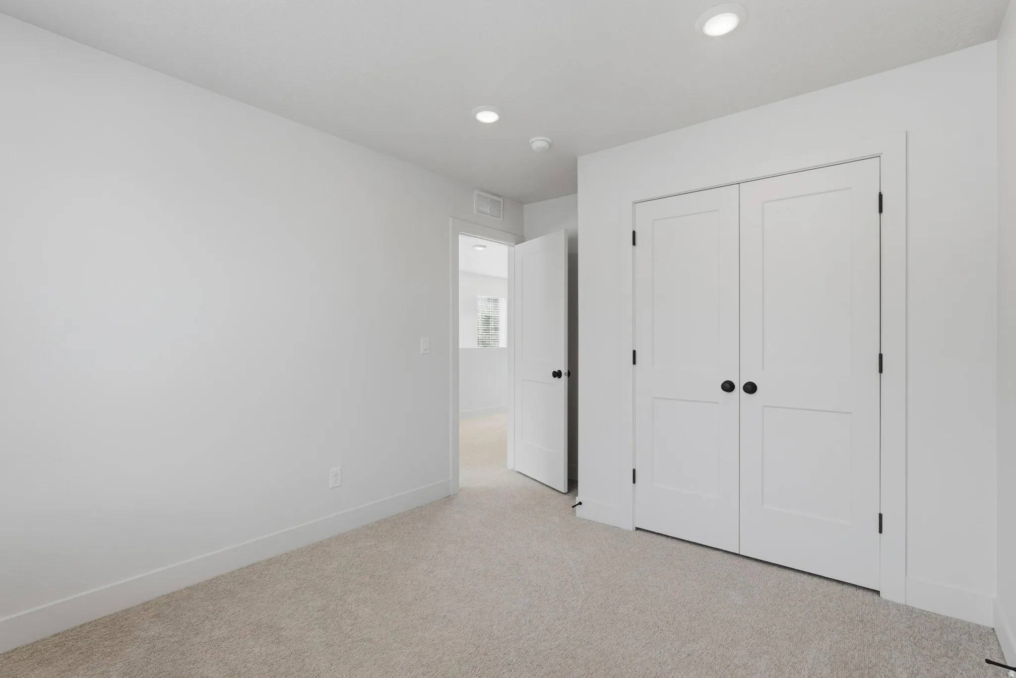Bedroom featuring neutral carpeting and white baseboards