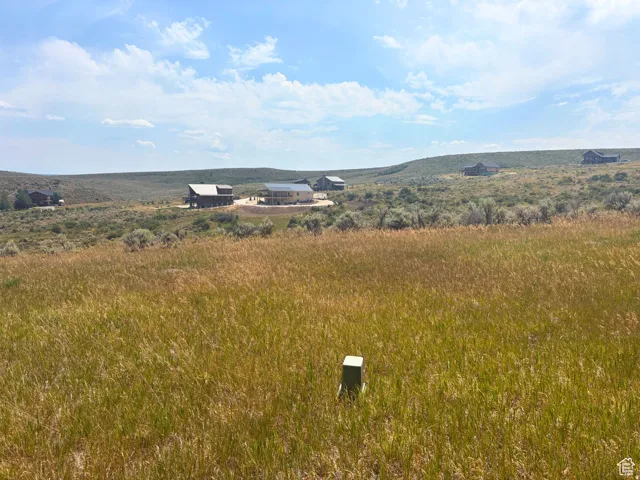 Expansive grass-covered landscape under a partly cloudy sky