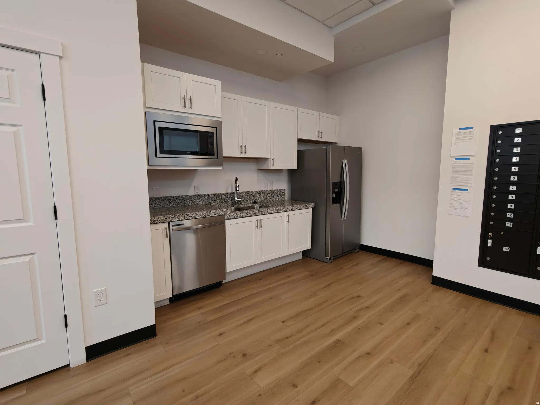 Full kitchen featuring white cabinetry, granite-style countertops, and stainless steel appliances