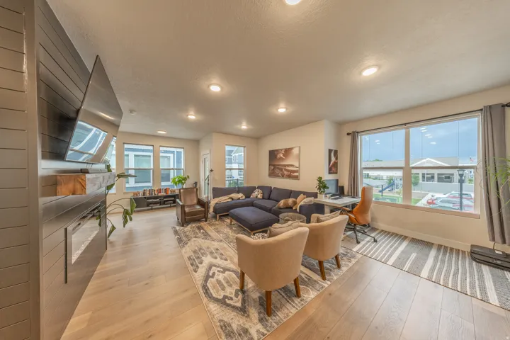 Spacious living area featuring wood-finish flooring, recessed lighting, and large windows