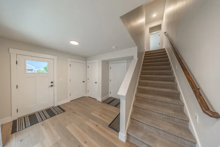 Entryway featuring wood-finish flooring, a white front door with clear glass pane, and recessed lighting