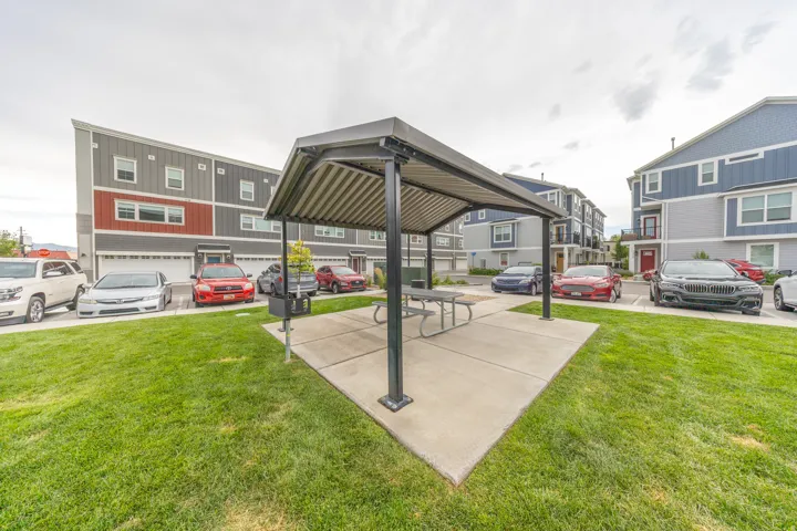 Central communal green space featuring a covered picnic area with a concrete pad and a metal picnic table