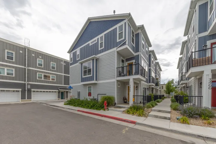 Contemporary multi-level townhome featuring a blue and gray siding exterior