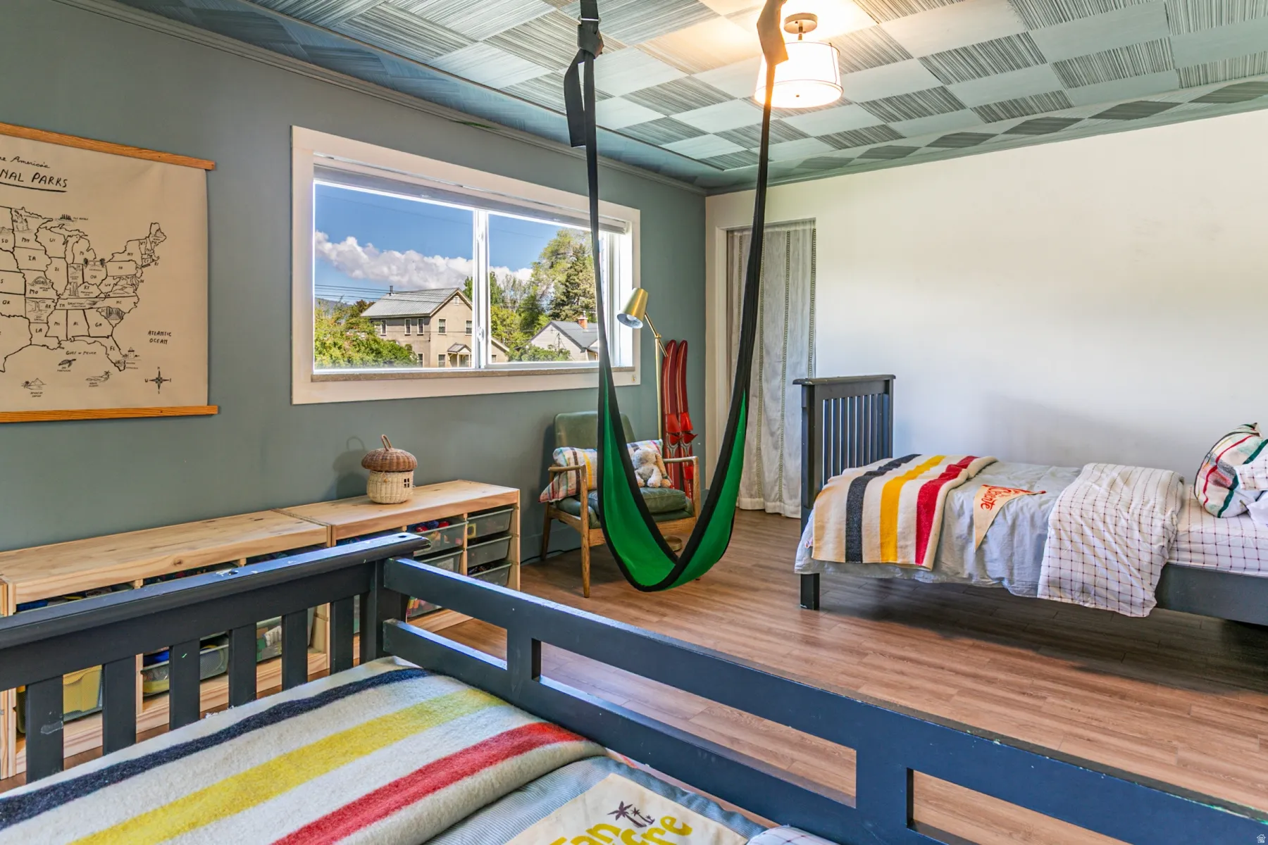 Spacious room featuring wood-finish flooring and a distinctive patterned ceiling