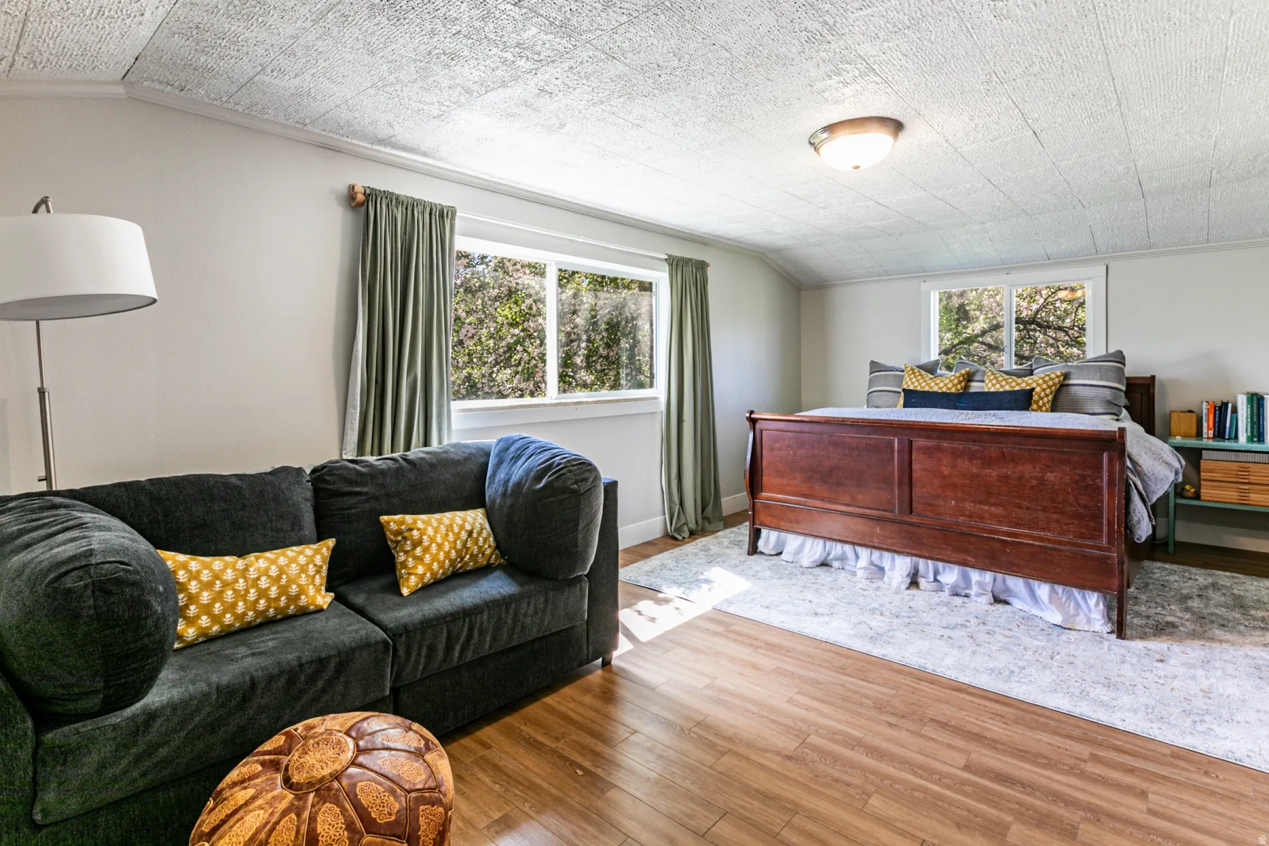 Spacious room featuring wood-finish flooring, multiple windows providing natural light, and a textured ceiling