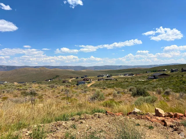 Expansive undeveloped land featuring rolling hills and distant mountain ranges