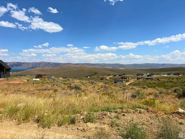 Expansive undeveloped land featuring a broad vista of rolling hills and distant bodies of water