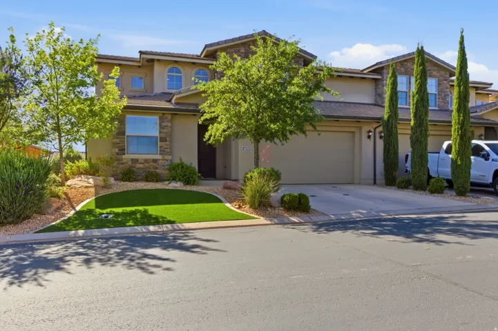 Tan stucco exterior with stone accents and a tile roof