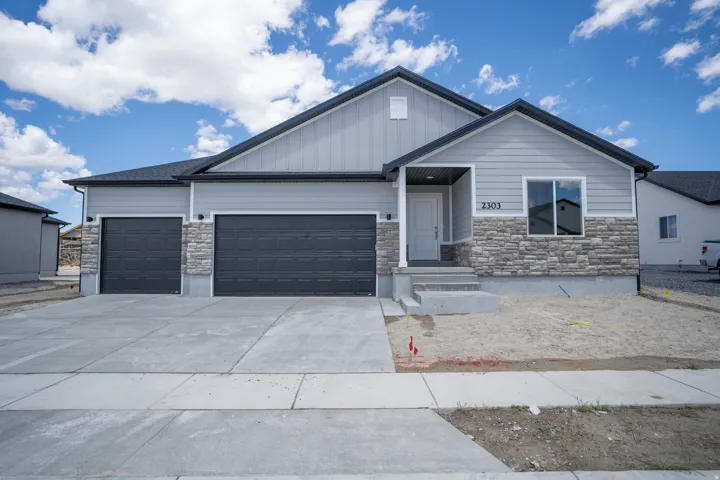 Contemporary residence featuring gray siding and stone veneer accents