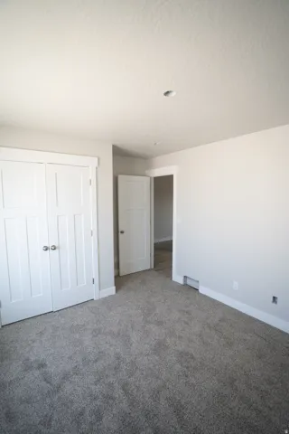 Room featuring plush gray carpeting, white trim, and a recessed ceiling light