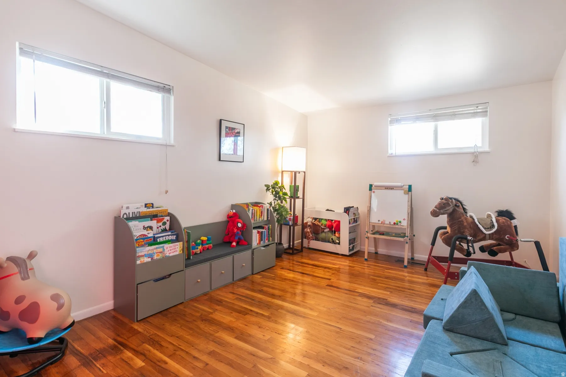 Large bedroom with hardwood flooring, large closet and two windows.