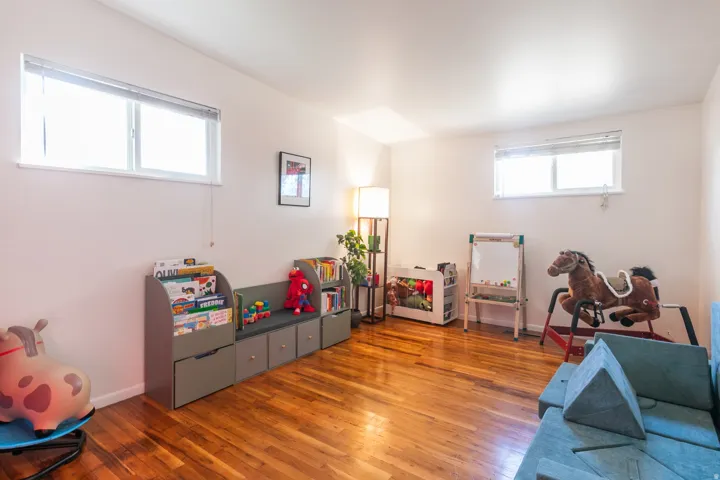 Large bedroom with hardwood flooring, large closet and two windows.