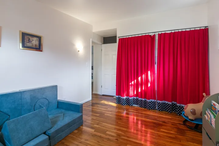 Large bedroom with hardwood flooring, large closet.