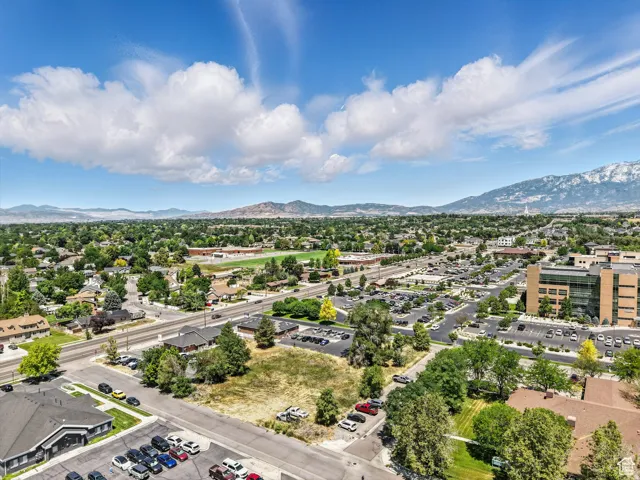Expansive aerial showcasing a broad urban landscape with distant snow-capped mountains