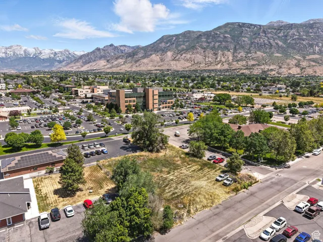 Expansive undeveloped lot featuring substantial street frontage, mature perimeter trees, and a mountain backdrop