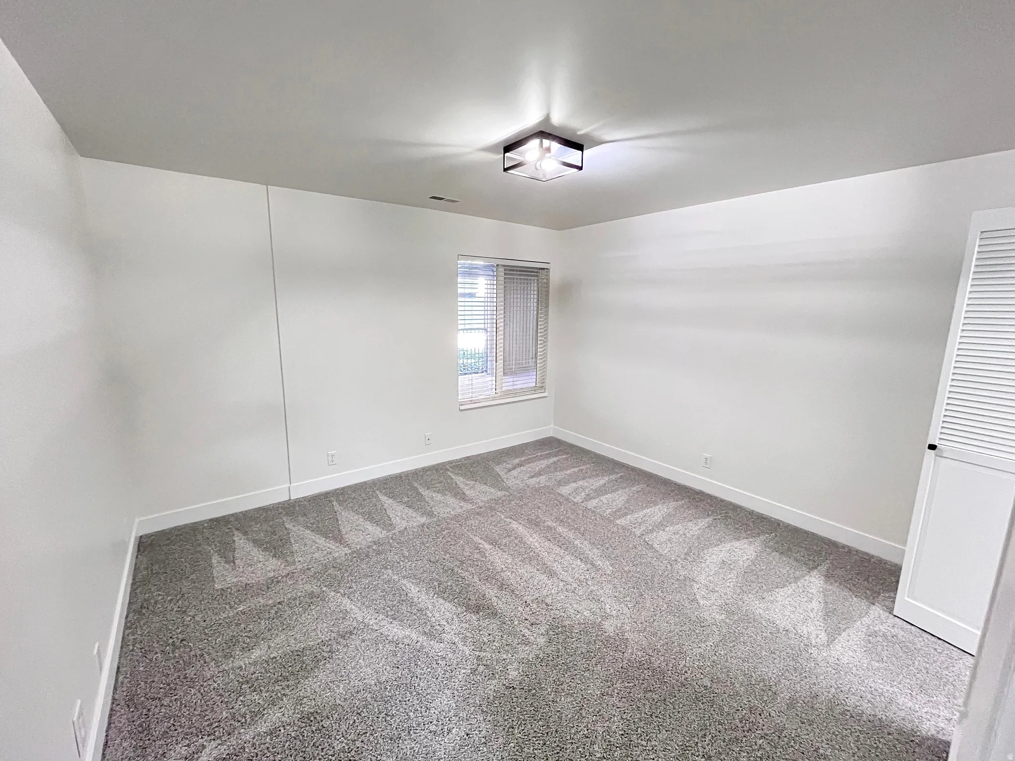 Second Bedroom featuring tall baseboards, cozy plush carpet, warm tones, and convenient bathroom access through a walk-in closet