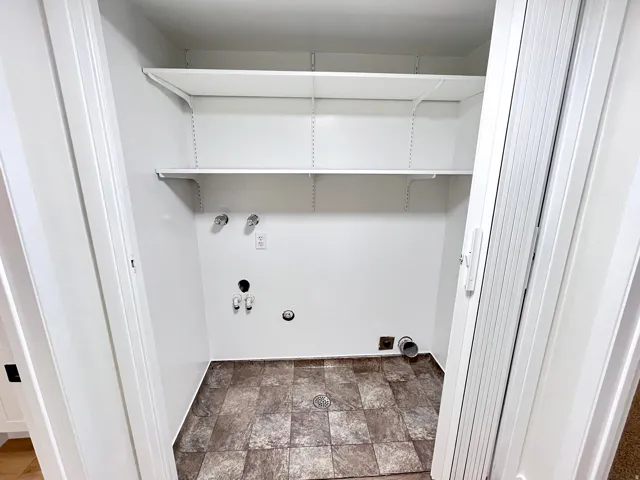 Laundry area featuring easy to clean flooring, hookup for a washing machine, and electric dryer hookup, and shelves for storage