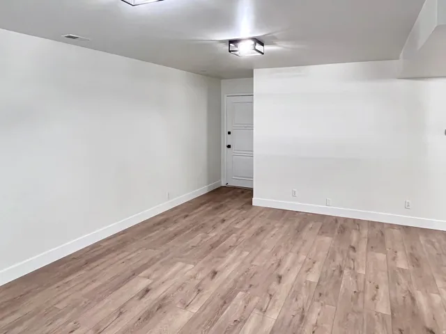 Living room featuring warm tones, fresh wood style flooring and newly painted timeless two-toned paint with large, modern baseboards
