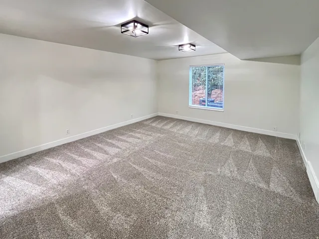 VIRTUALLY STAGED-Primary Bedroom featuring tall baseboards, cozy plush carpet, warm tones, and convenient bathroom