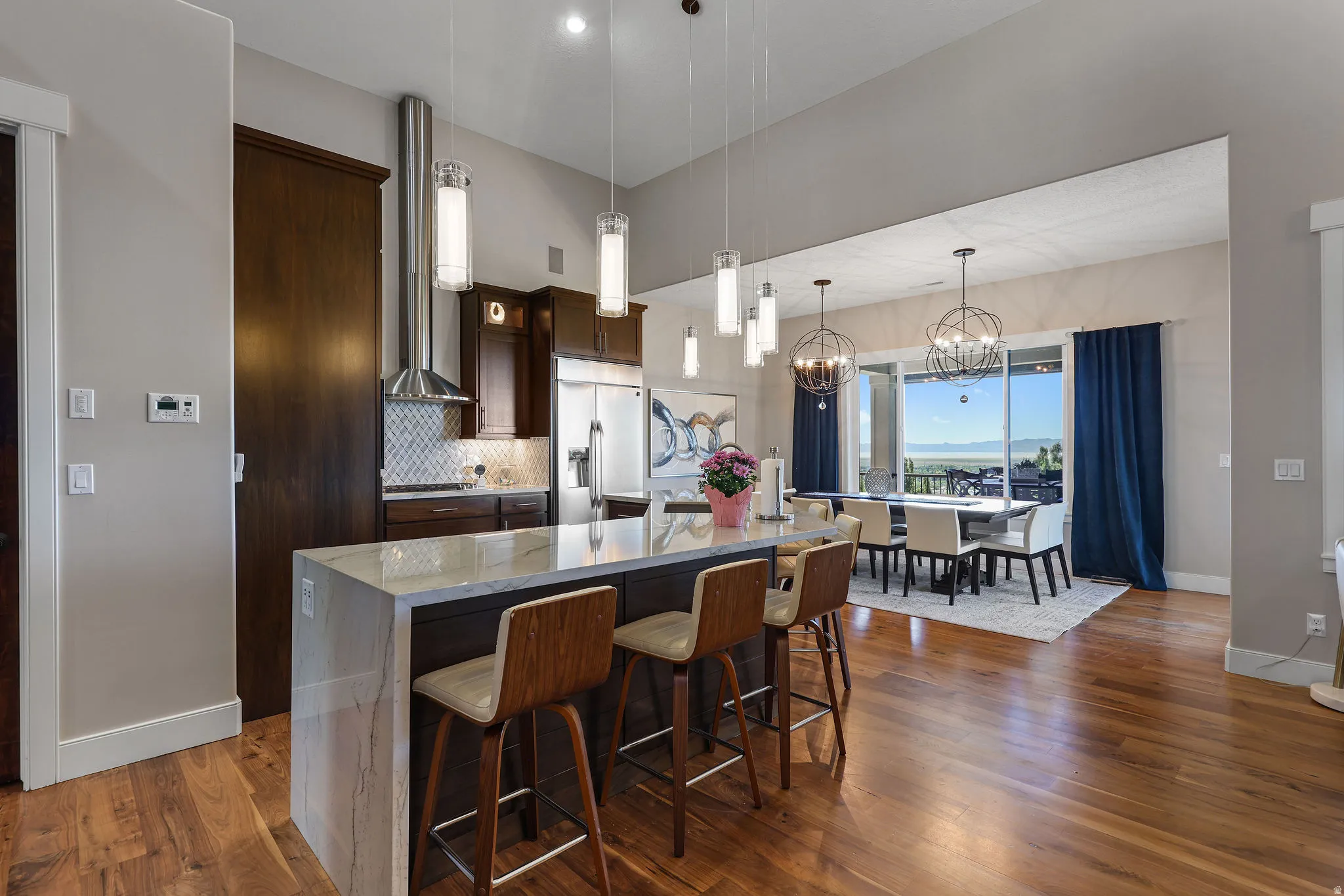 Open-concept kitchen and dining area featuring rich wood-finish flooring