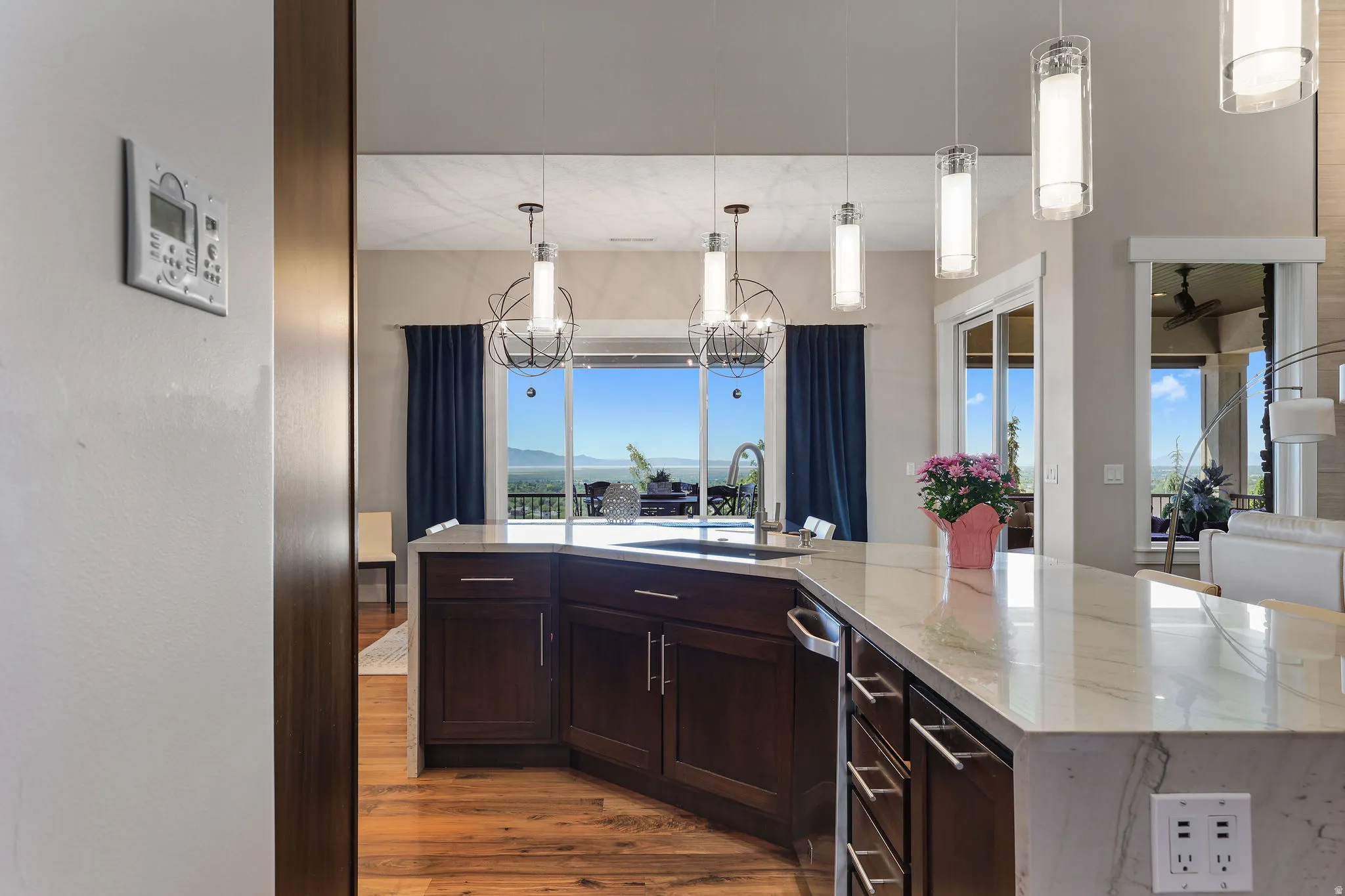 Kitchen island with dark wood-finish cabinetry, light-toned countertops, and an undermount sink