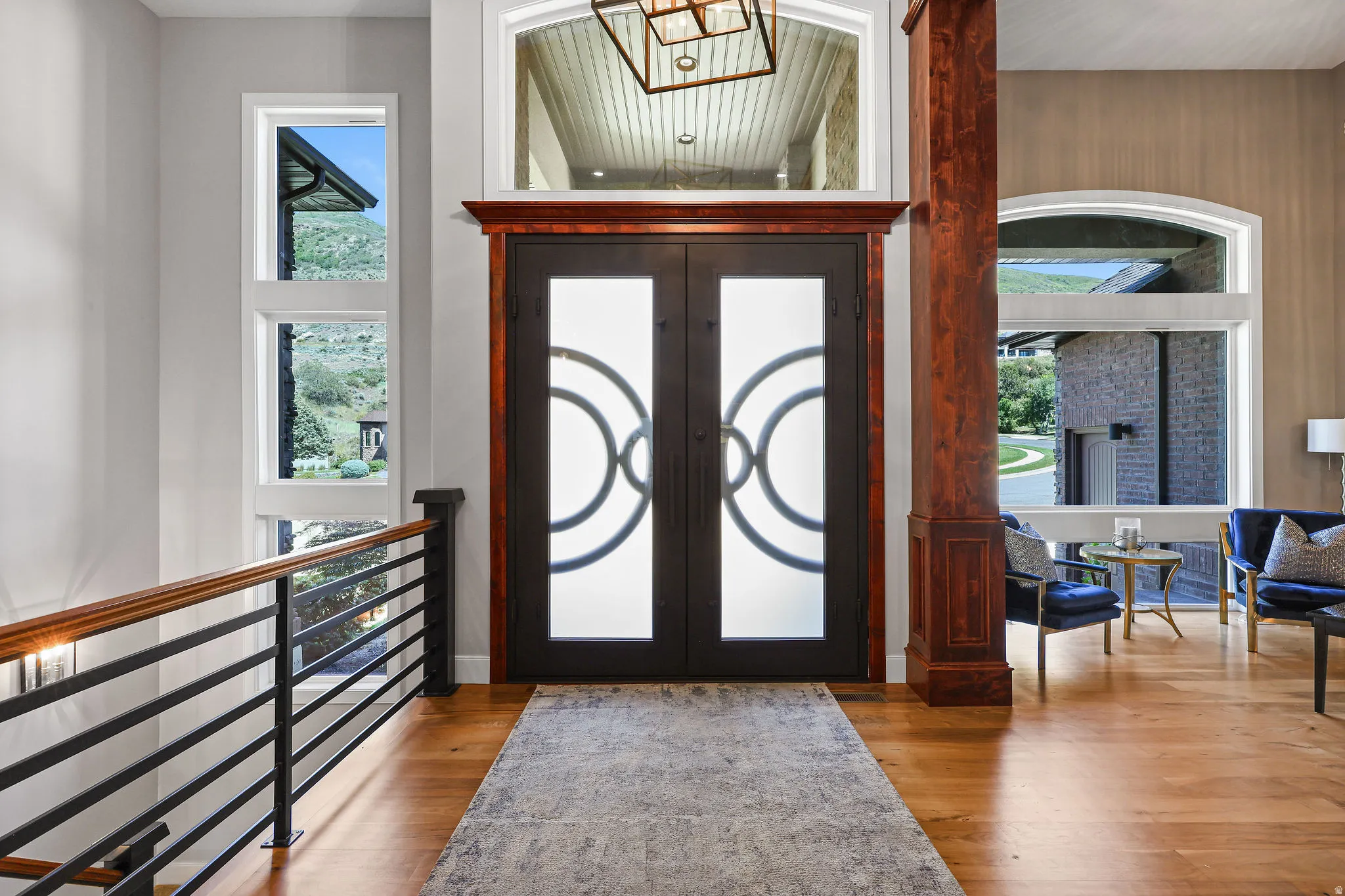 Grand entry featuring a double door with decorative glass, rich wood-finish trim, and a transom window