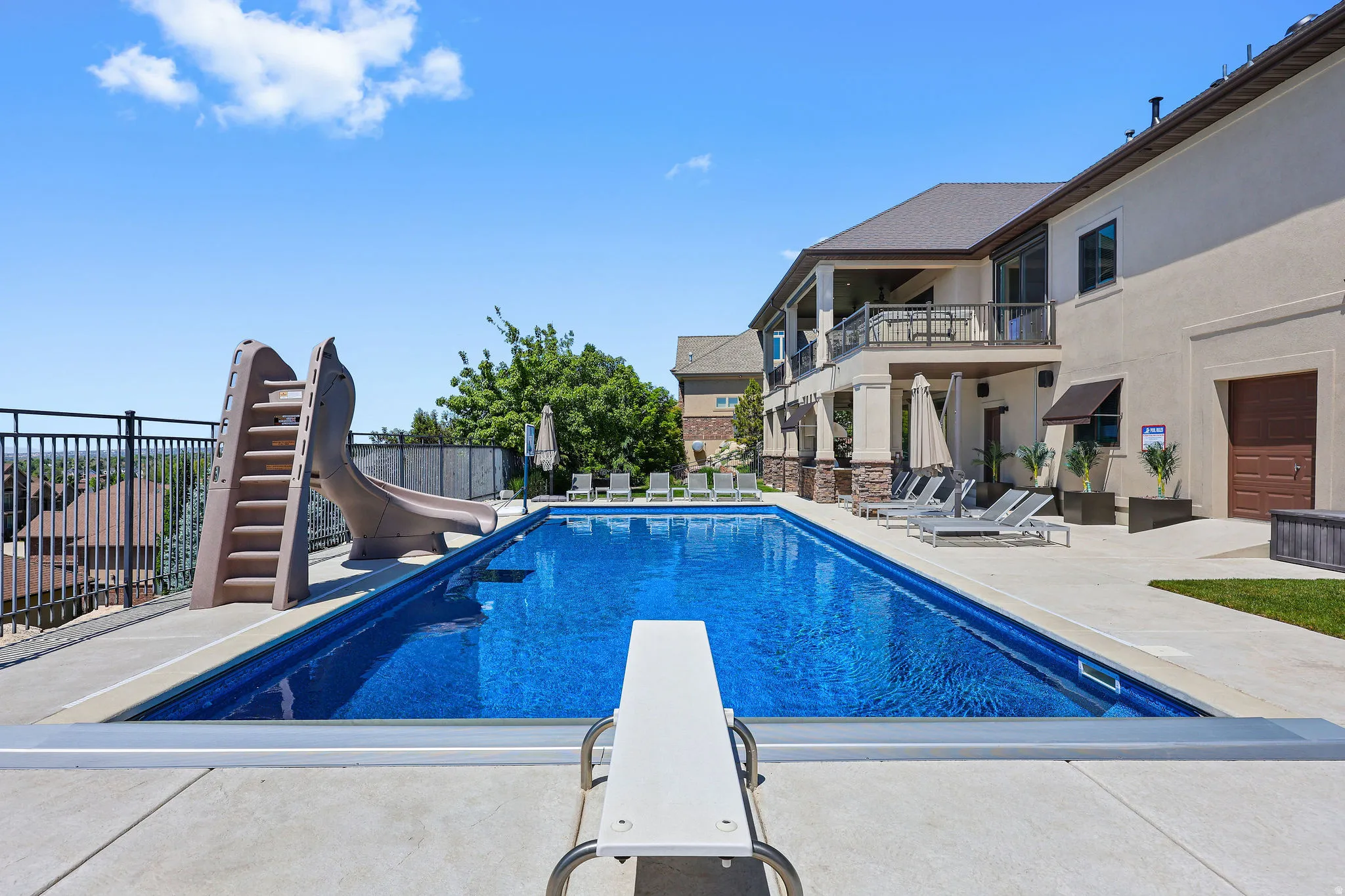 Rectangular in-ground pool with a diving board and attached slide