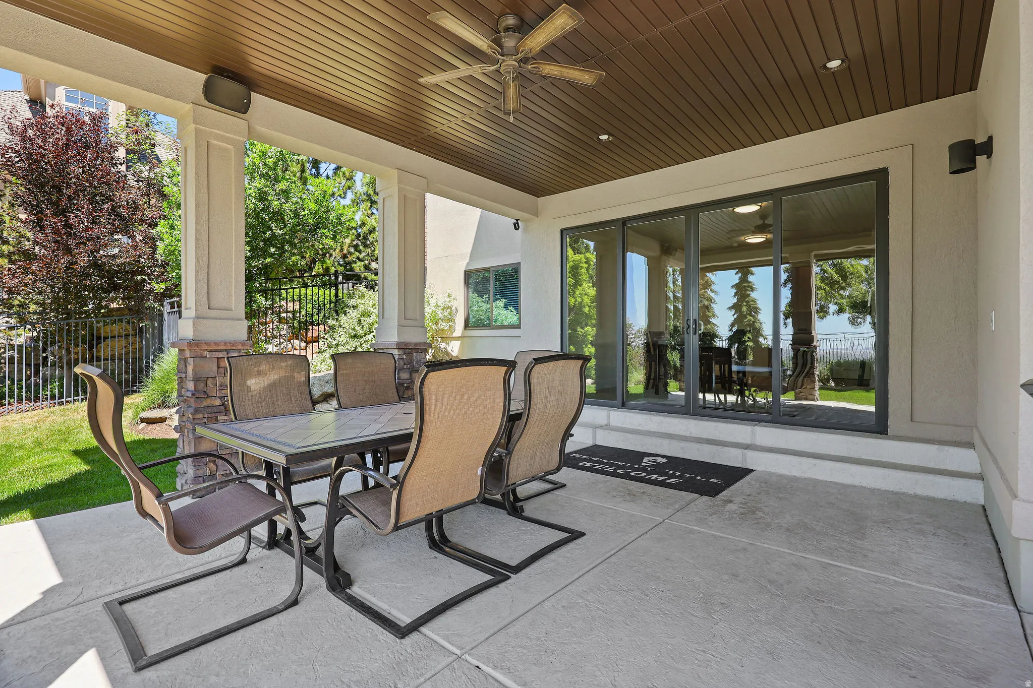 Covered concrete patio featuring a wood-panel ceiling with a ceiling fan, recessed lighting, and integrated speakers