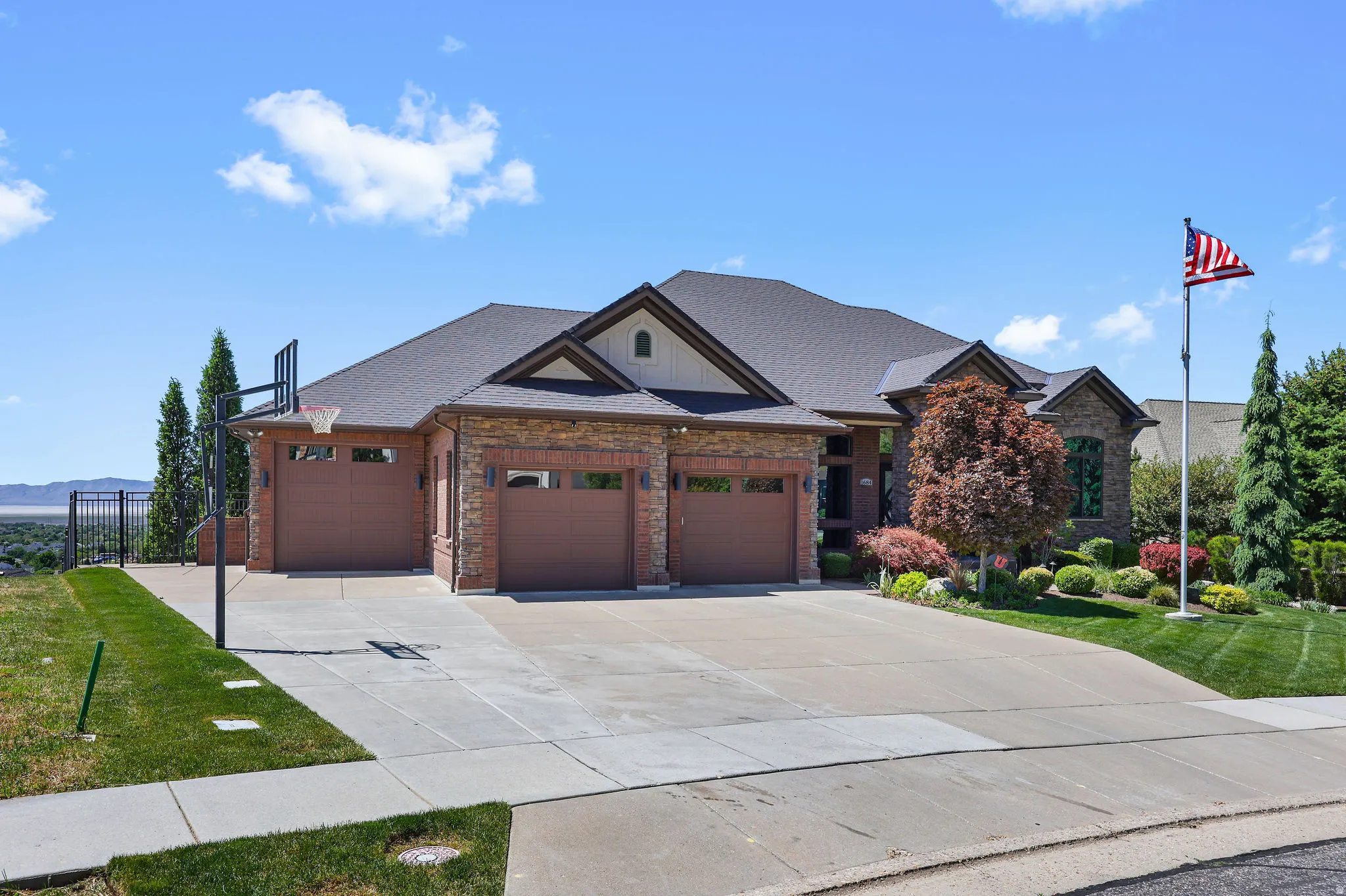 Brick and stone exterior with a dark shingle roof
