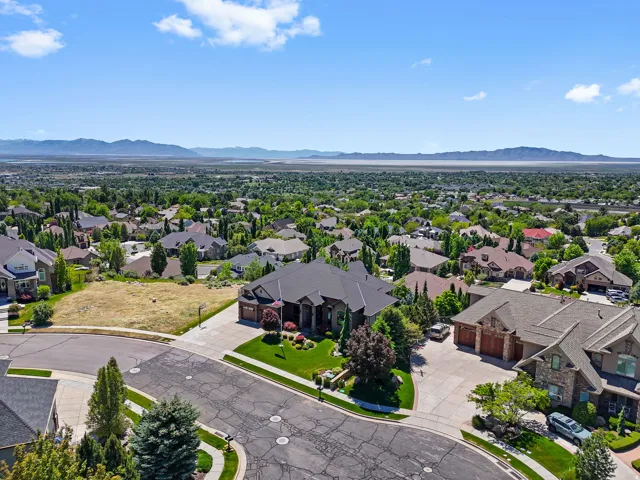 Expansive residential area featuring numerous properties amidst extensive greenery and distant mountain ranges