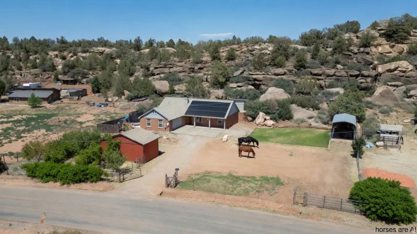 Ranch-style residence featuring a brick and siding exterior, an attached garage, and visible rooftop solar panels