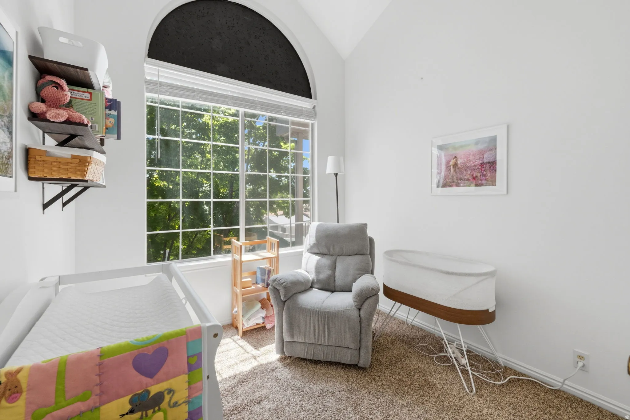 Room featuring a large arched window with grid detailing, white window blinds, and an upper arched shade