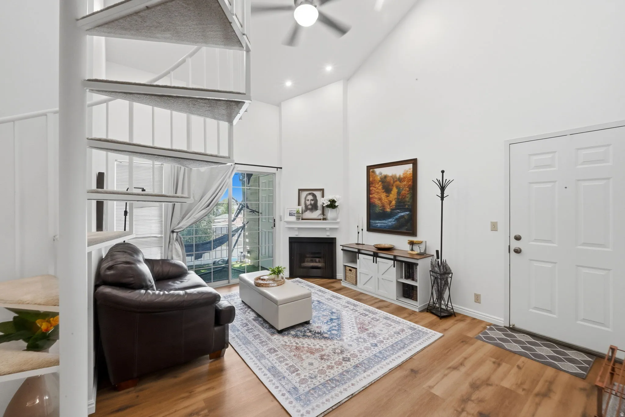 Living area featuring a spiral staircase, high vaulted ceilings, and wood-finish flooring