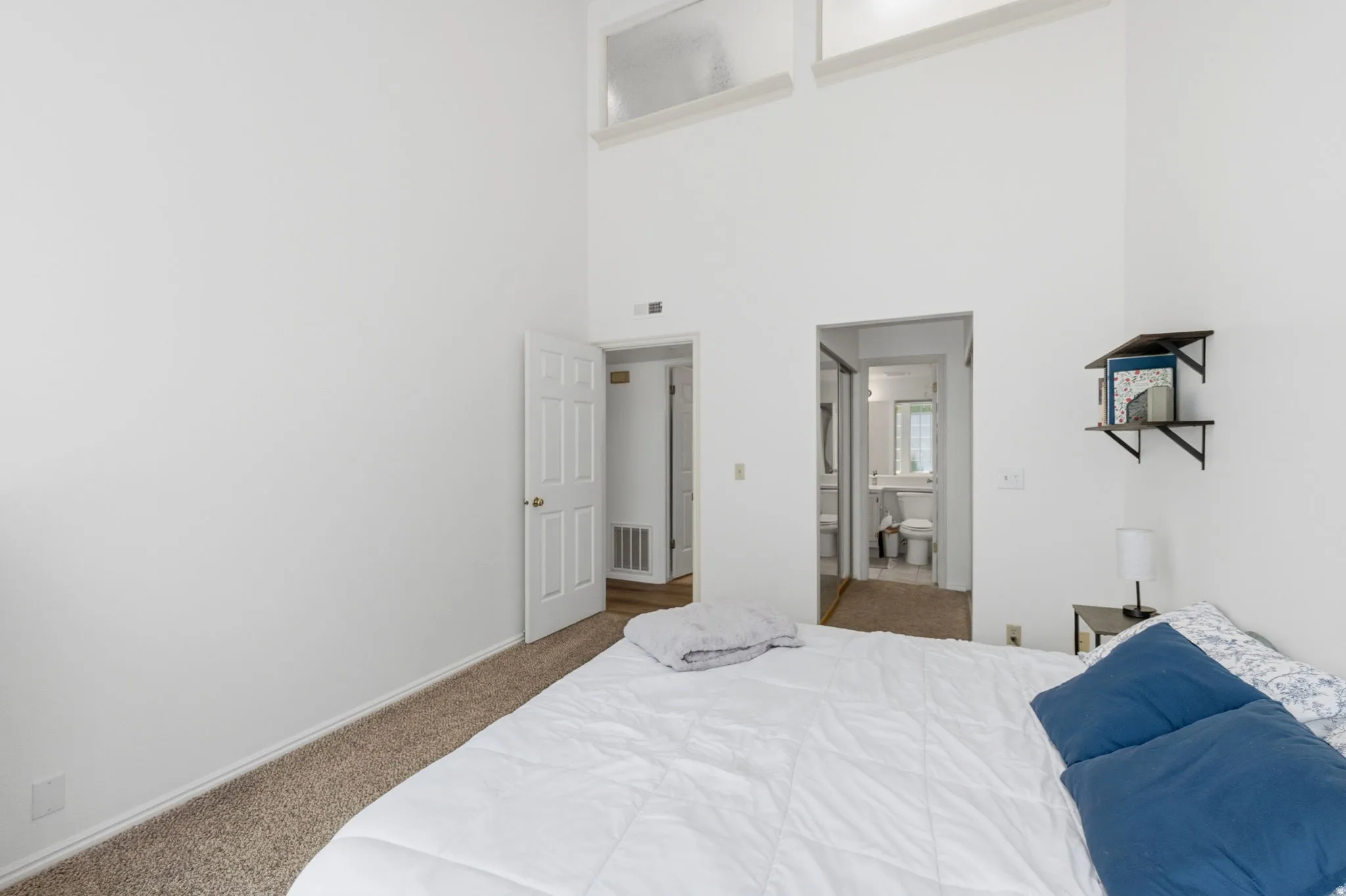 Vaulted ceilings with high transom windows enhance this bedroom space