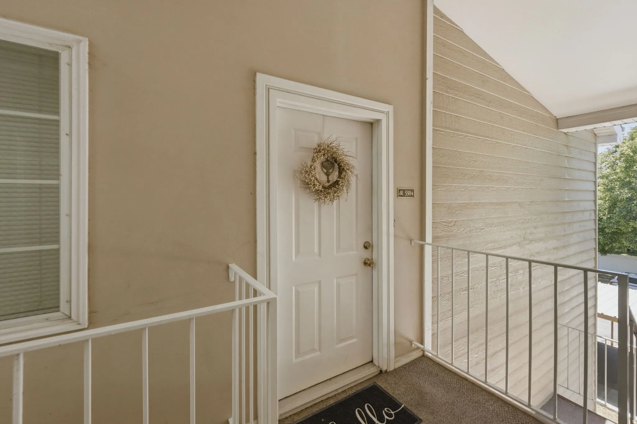 Entryway featuring a white paneled door, light-toned exterior walls, and a white framed window